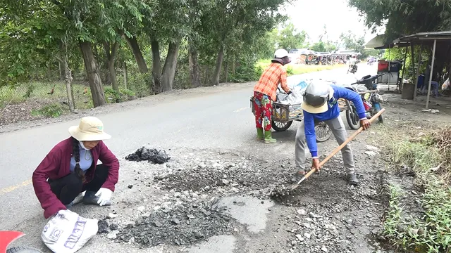 Chị Minh (trái) dầm mưa dãi nắng vá đường