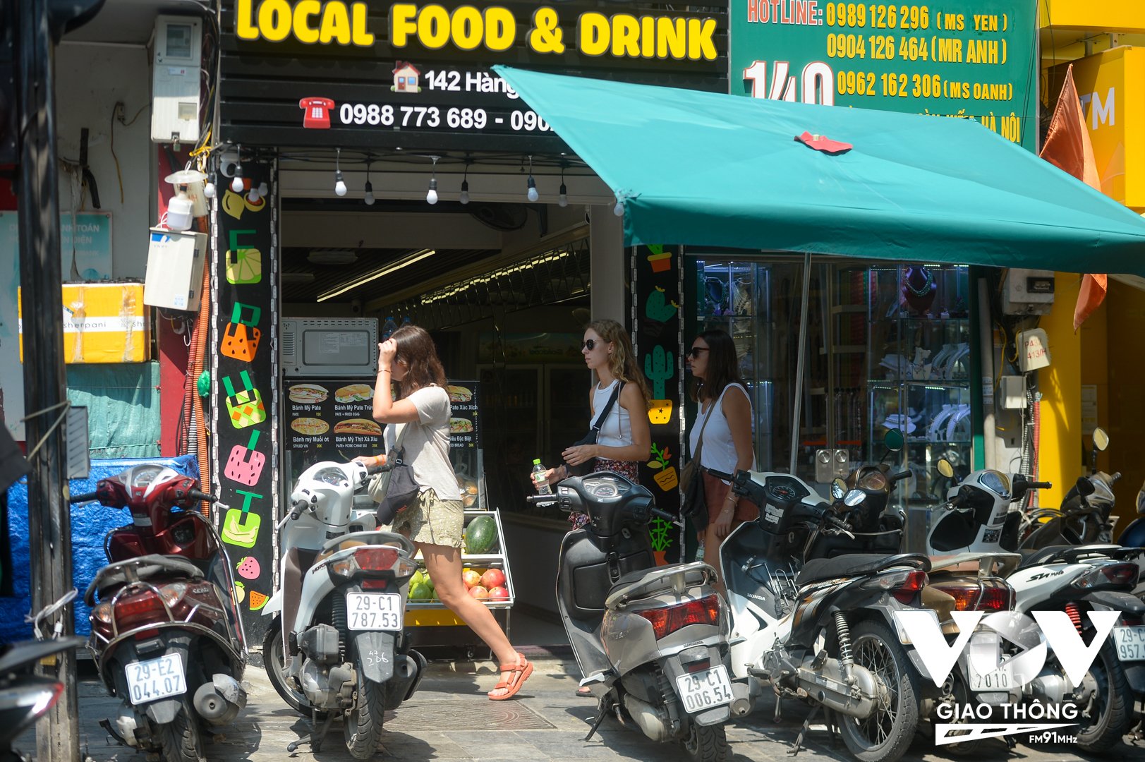 Khách du lịch len lỏi qua hàng xe máy trên phố Hàng Bạc, phường Hàng Bạc, quận Hoàn Kiếm, Hà Nội.