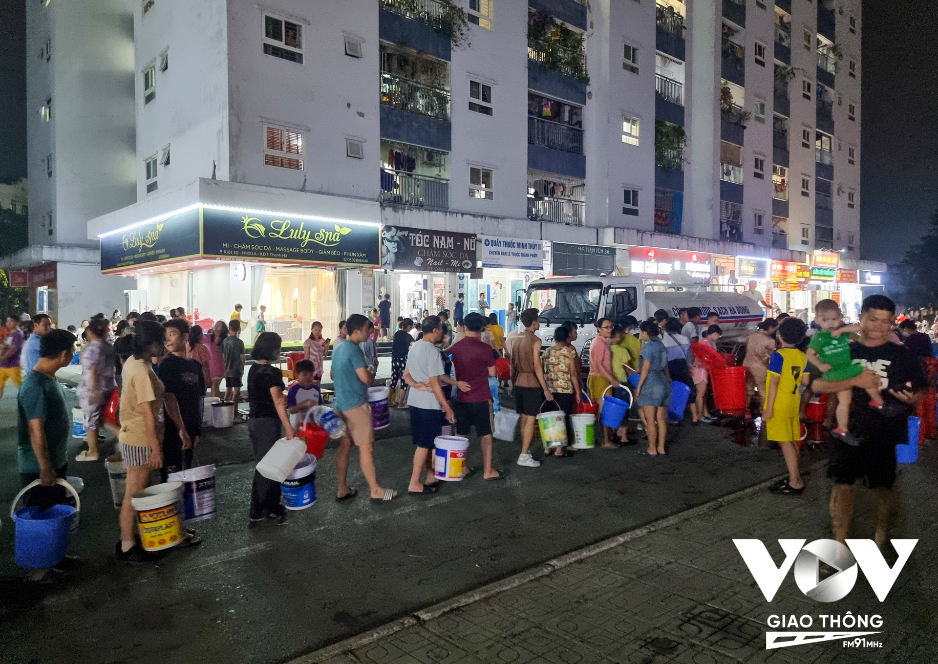 7h30 tối 22/10, cư dân Khu đô thị Thanh Hà xếp hàng chờ đợi lấy nước sạch từ xe bồn của các đơn vị hỗ trợ bà con