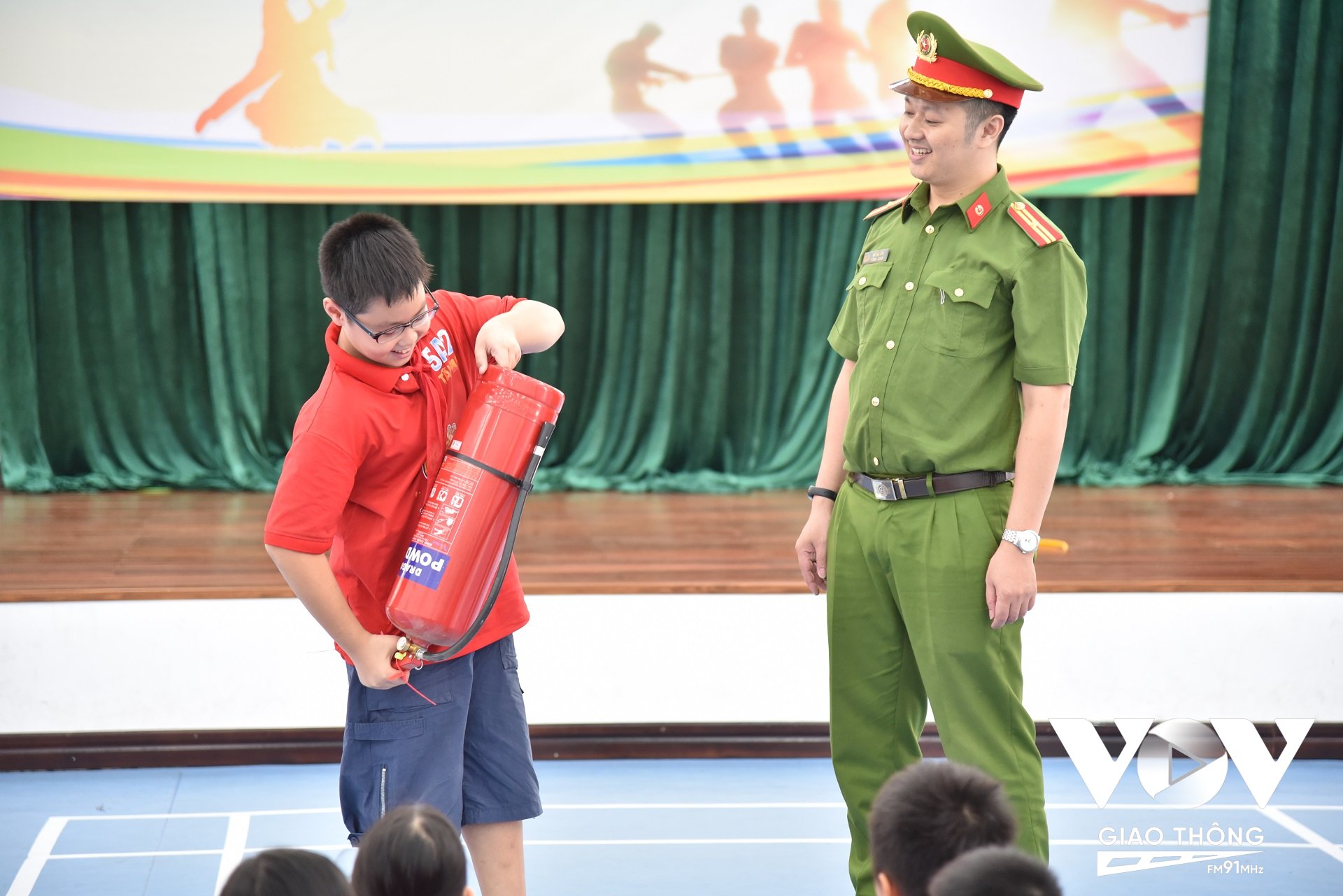 Thiếu tá Vũ Văn Sơn – Cán bộ Đội Cảnh sát PCCC&CNCH Công an quận Hoàng Mai trực tiếp hướng dẫn kỹ năng sử dụng bình chữa cháy cho các em học sinh