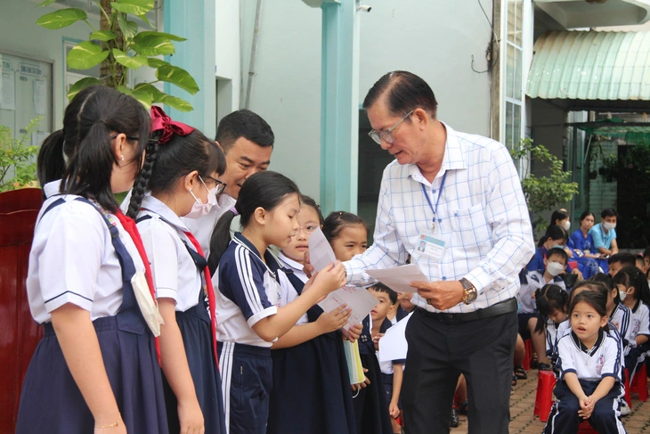 Thầy Khiêm trao giải viết chữ đẹp cho học sinh Trường tiểu học Hồng Bàng (TP Rạch Giá) - Ảnh: Tuổi trẻ