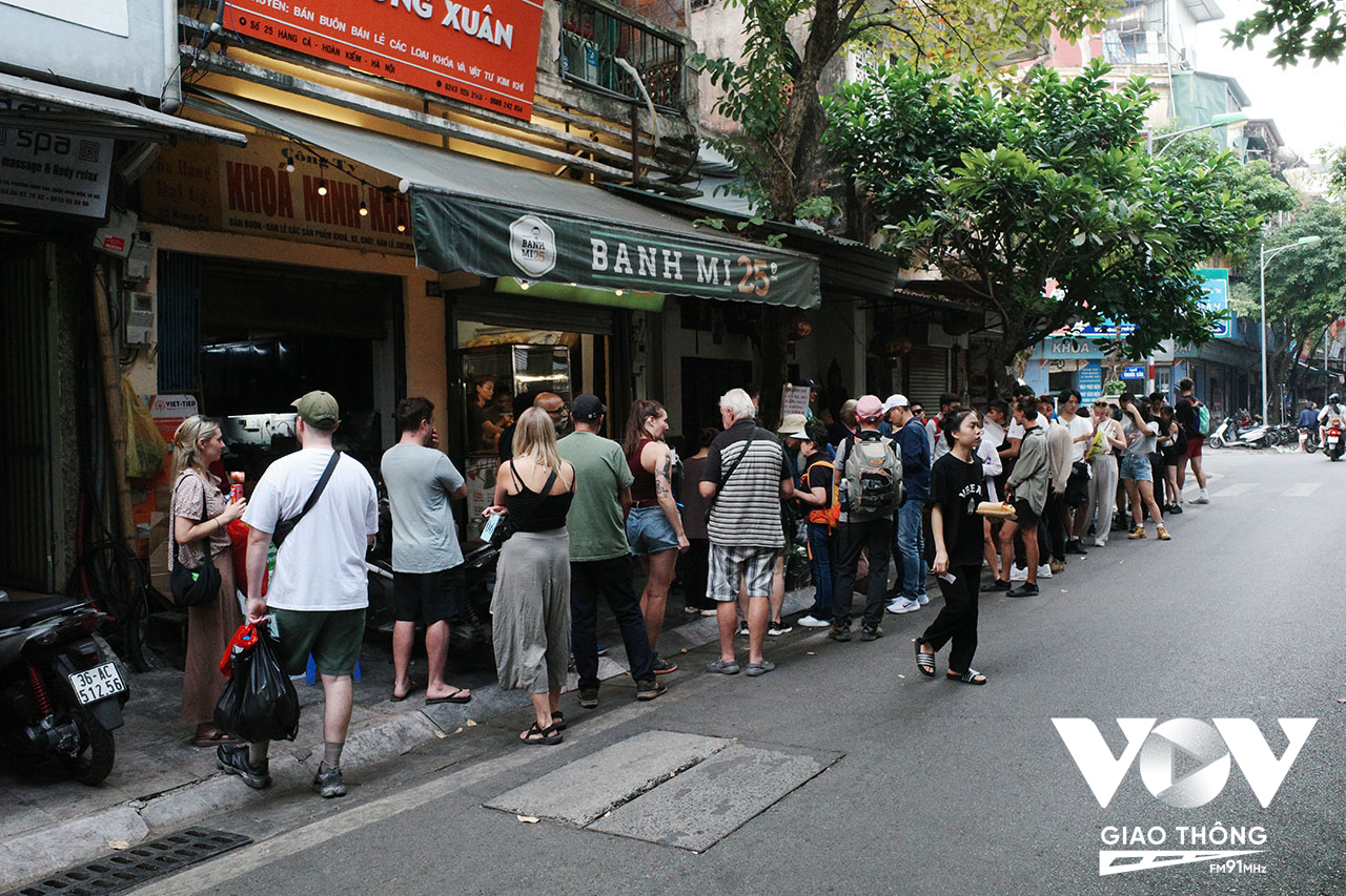 Những du khách nước ngoài kiên nhẫn đứng xếp hàng dài trên phố chờ mua bánh mì - bánh mì cũng là một món ăn đầy thú vị, hấp dẫn, đặc biệt với du khách