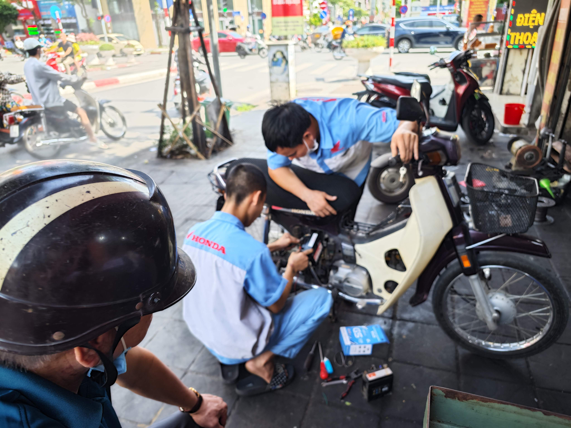 Không ít người đi xe máy ở Hà Nội bức xúc trước hiện tượng ngày một phổ biến là 'chặt chém' giá sửa chữa xe. Ảnh minh họa khách hàng ngồi chờ tại 1 tiệm sửa xe trên địa bàn quận Hoàng Mai.