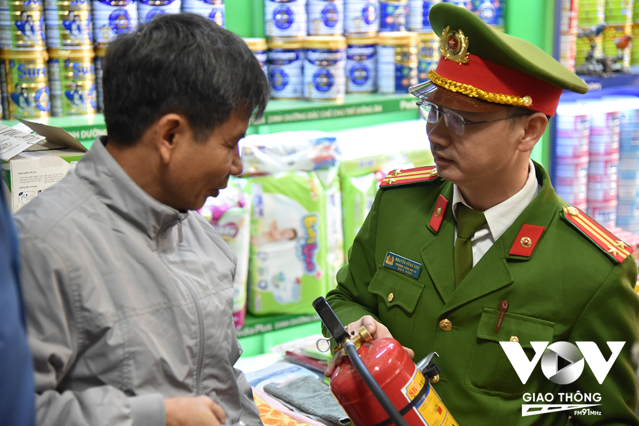 Trung tá Nguyễn Hồng Sơn – Trưởng công an xã Thái Hòa hướng dẫn sử dụng các thiết bị PCCC tại chỗ cho các hộ kinh doanh