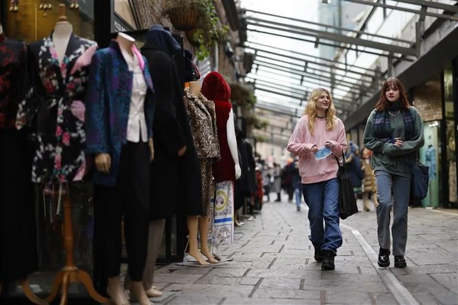 Người dân mua sắm tại một khu chợ ở London, Anh, ngày 7/1/2022. (Ảnh: AFP/TTXVN)