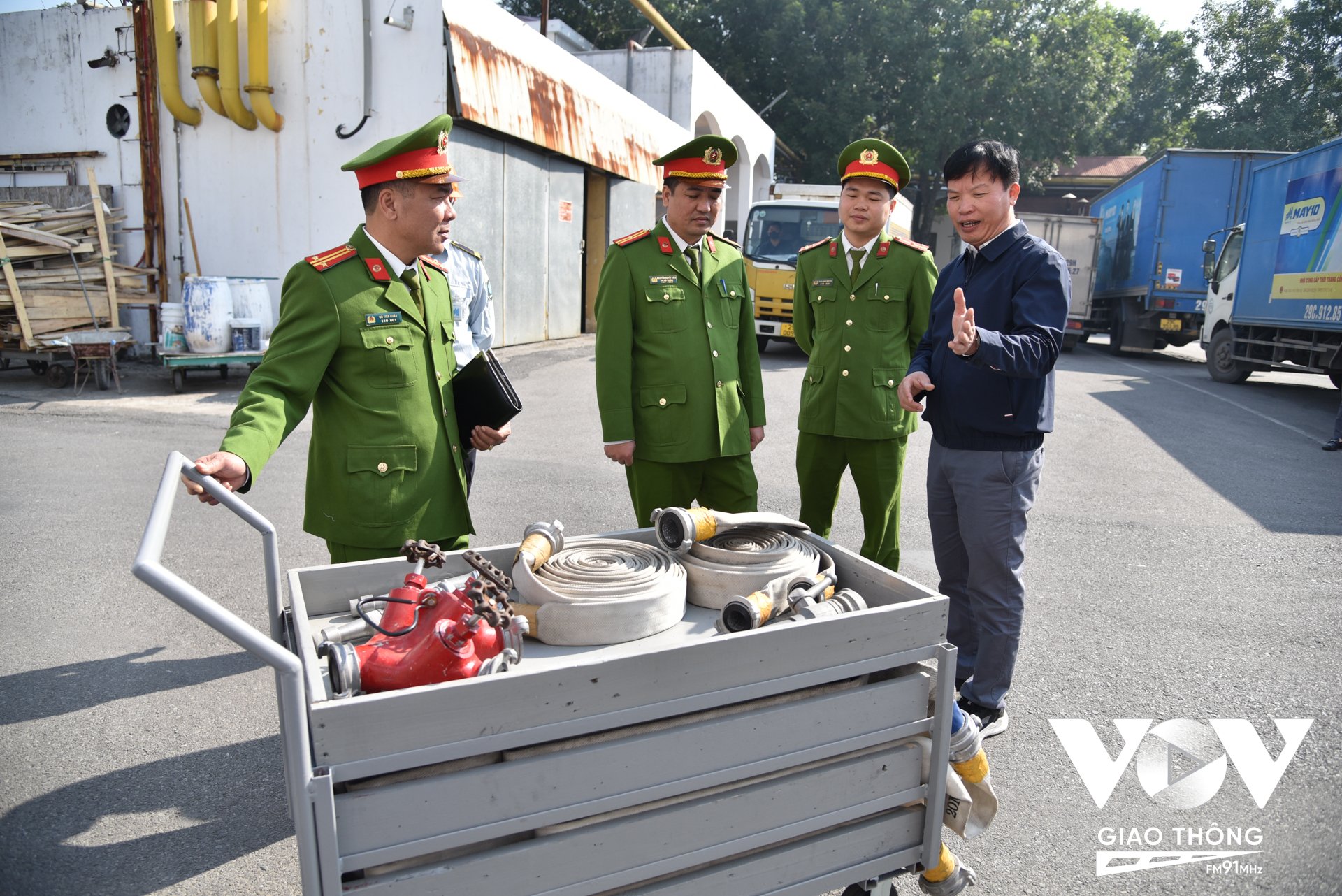 Ông Bạch Ngọc Lân (ngoài cùng bên trái) – Trưởng phòng Bảo vệ Quân sự Tổng công ty May 10 giới thiệu về chiếc xe rải vòi bán tự động