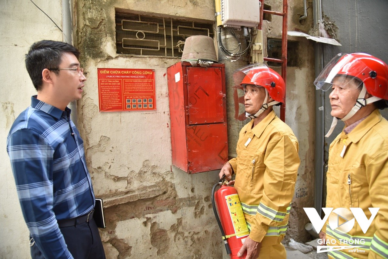 Ông Mạc Trung Kiên – Phó Chủ tịch UBND phường Thanh Xuân Trung trao đổi với các thành viên đội PCCC dân phòng. Phía sau là một điểm chữa cháy công cộng được người dân trang bị từ năm 2019