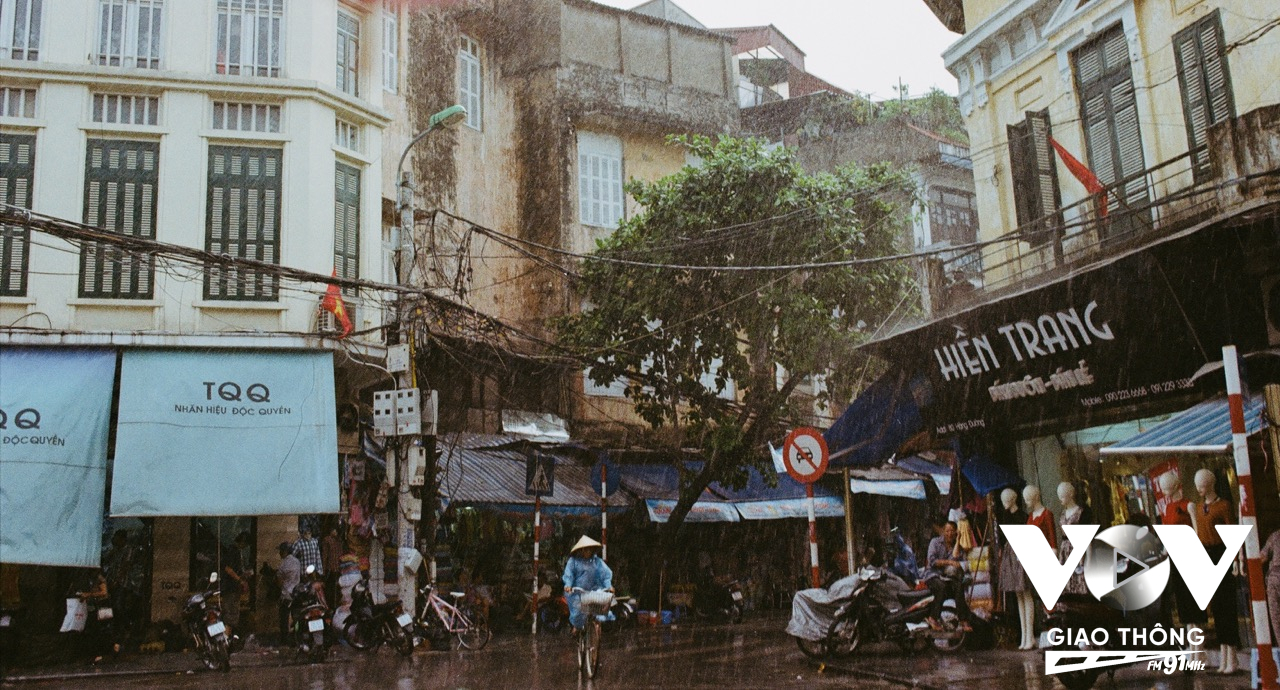 Trong màn mưa, ai đó chậm lại, ai đó lại vội vã hơn lớn (Ảnh: Ái Kiều/VOVGT)