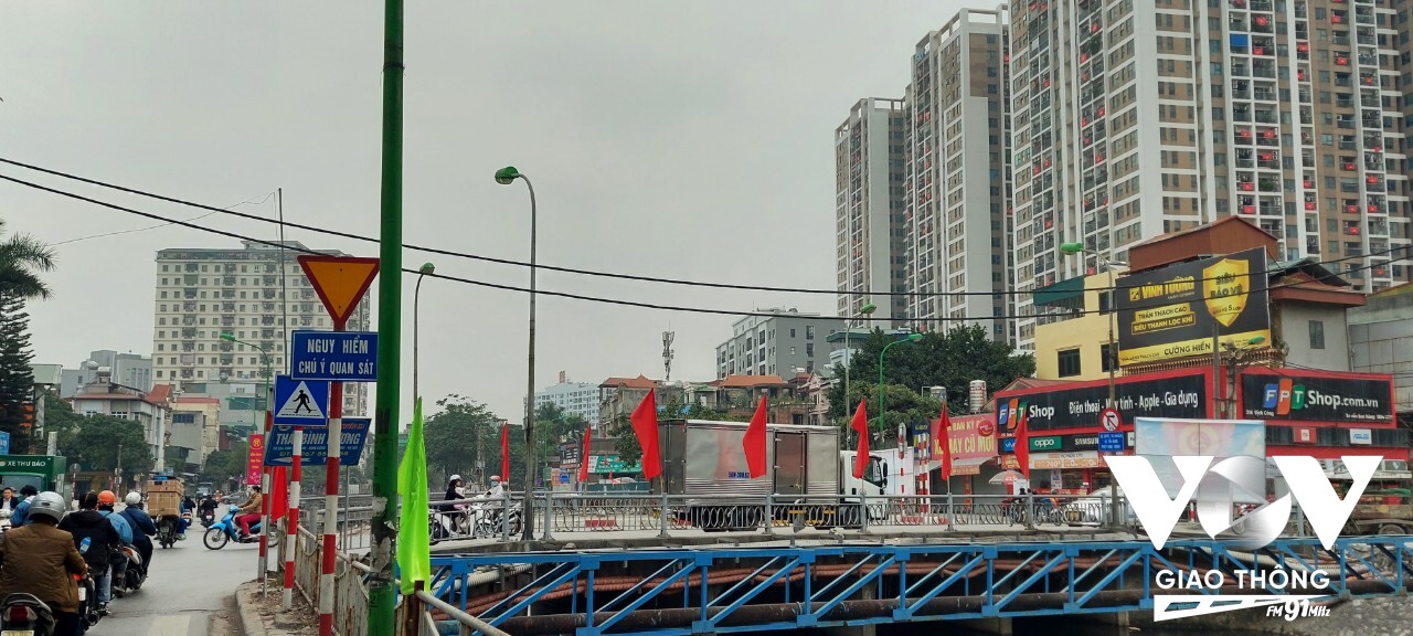Một góc cầu Định Công, hồng kỳ trên cầu và quốc kỳ trên những ô cửa chung cư