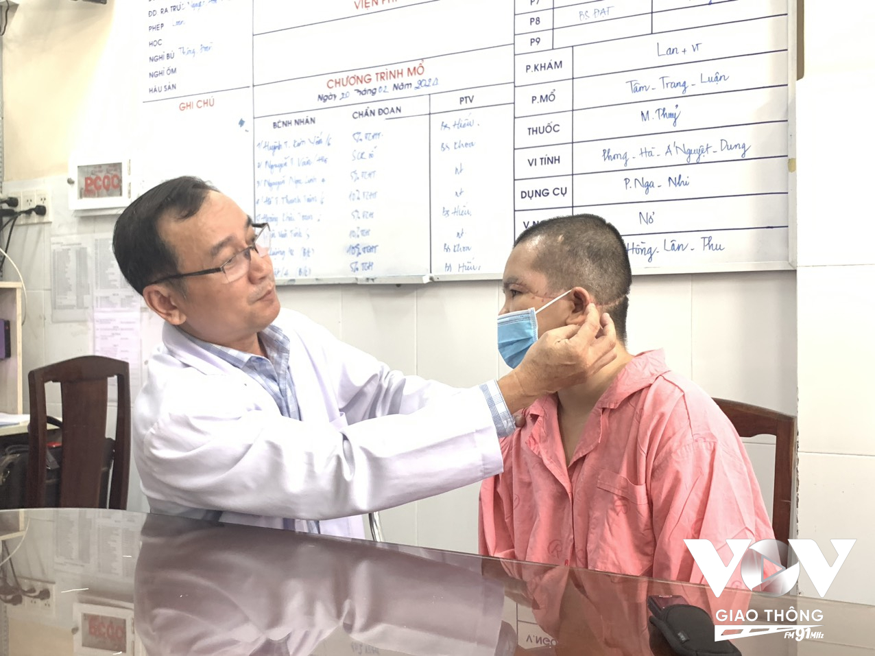 Bác sĩ điều trị đang khám vết thương ở vùng tai cho bệnh nhân