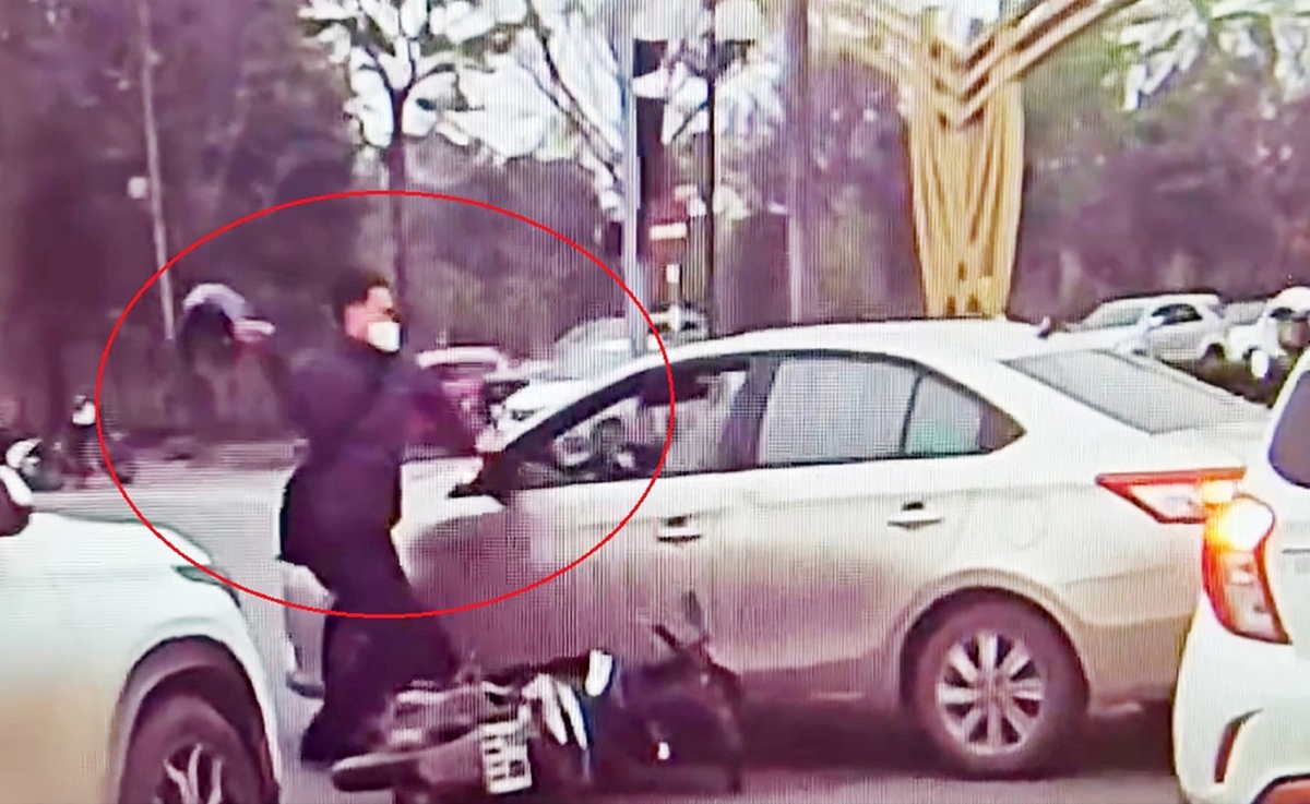 Thanh niên sau khi va chạm giao thông đã dùng mũ bảo hiểm đập vỡ kính xe hôm 13/3 tại TP Vinh, Nghệ An - Ảnh chụp lại từ video