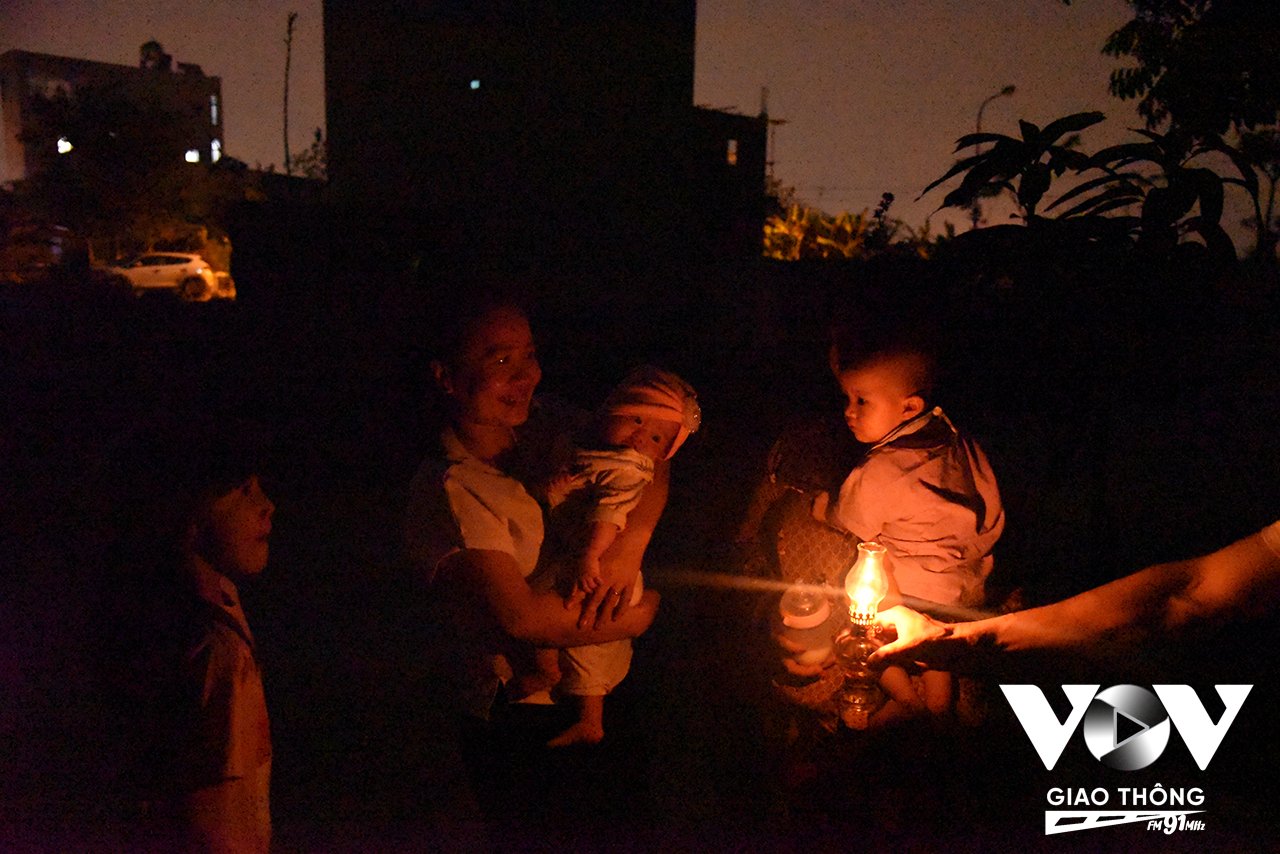Nhiều gia đình phải bế con nhỏ đứng hóng gió ngoài cửa vì chẳng thể có điện để dùng quạt hay điều hòa.