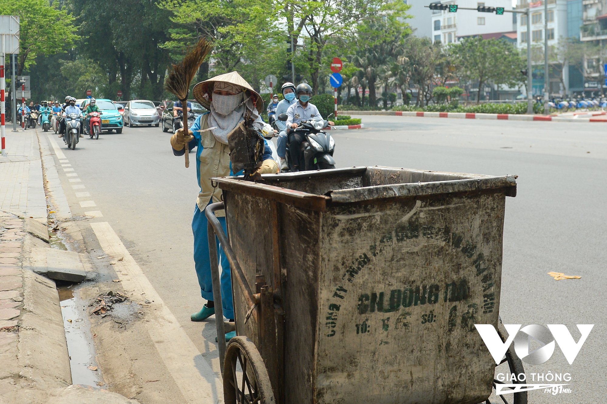 Ở một góc khác, người công nhân vệ sinh môi trường vẫn đang cần mẫn thực hiện công việc.