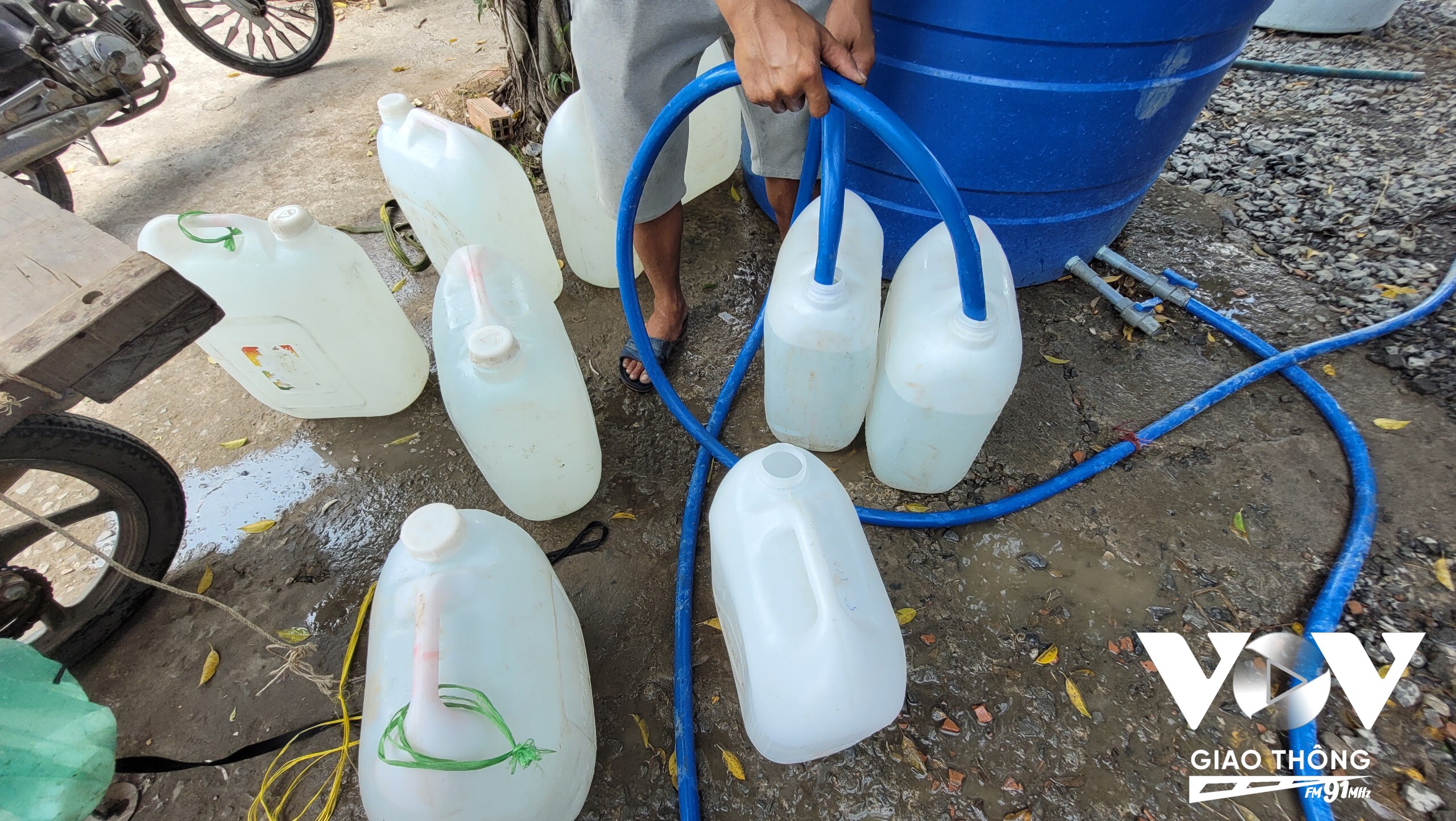 Chiết nước từ bồn để mang vào nhà cho các hộ dân ở sâu trong ấp