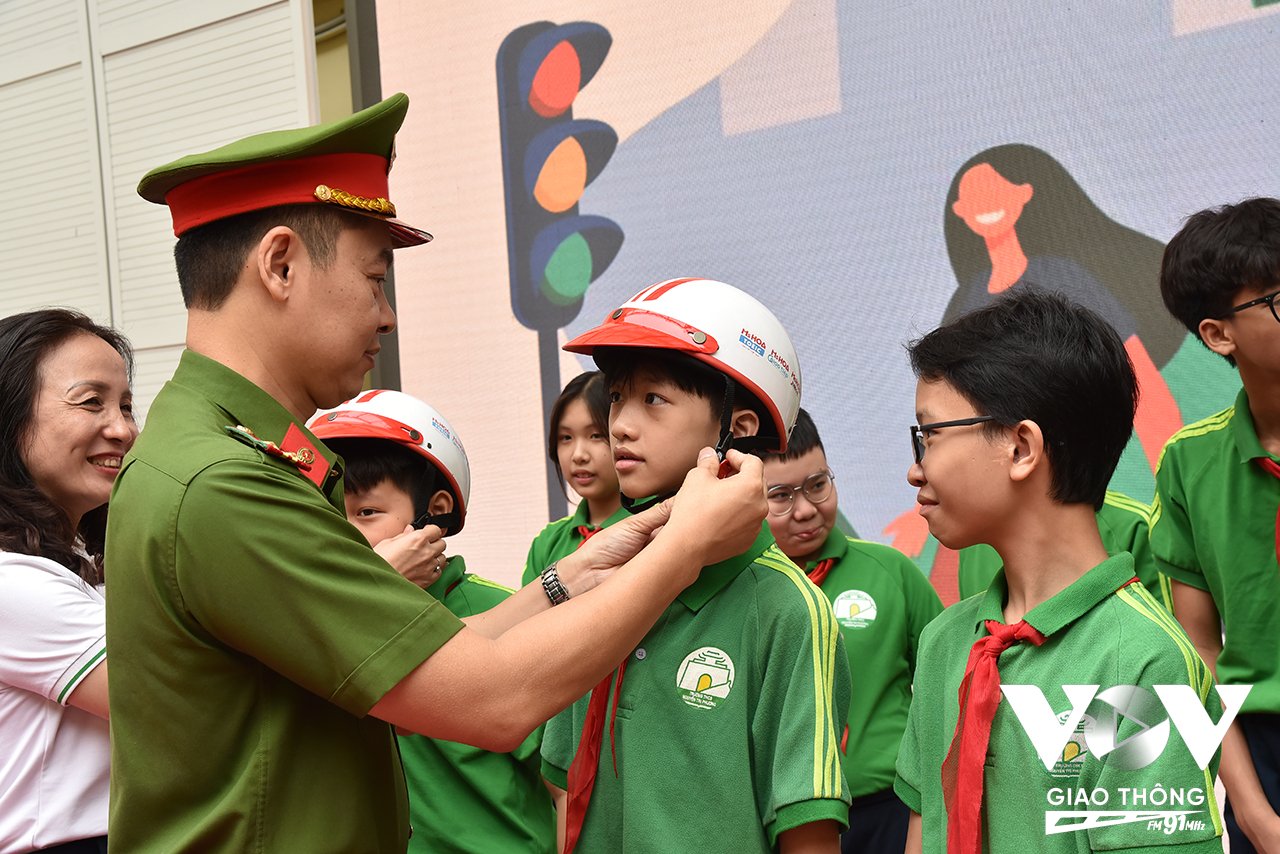 Công an quận Ba Đình tặng mũ bảo hiểm cho các em học sinh trường THCS Nguyễn Tri Phương.
