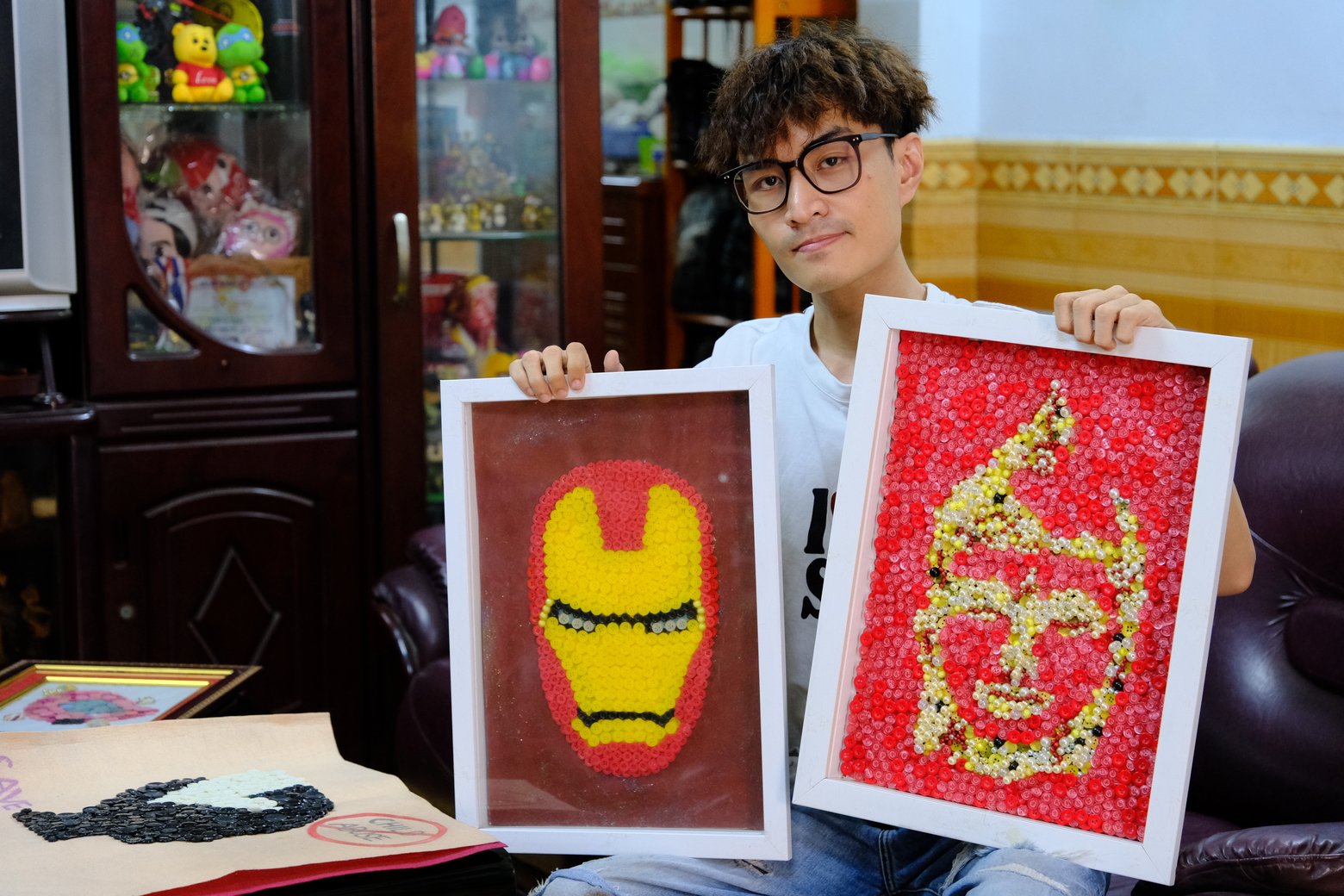 Nguyễn Phước Quý Thành (sinh năm 1993) cùng những bức tranh nghệ thuật tạo nên từ nút áo, vỏ dây điện...
