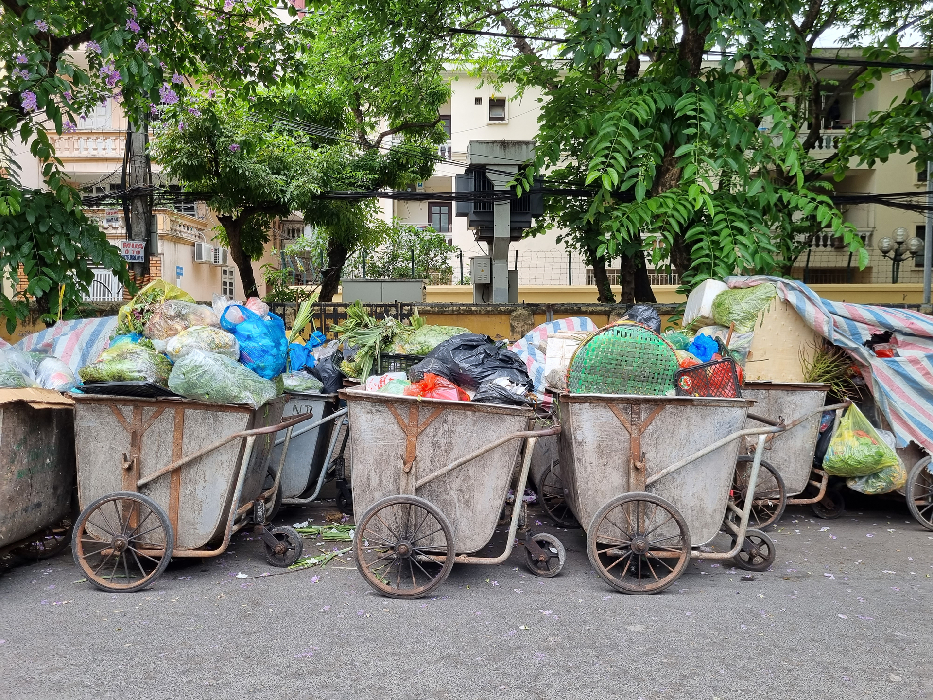 Nhiều công nhân vệ sinh môi trường băn khoăn, không biết sẽ thu gom, vận chuyển rác đã được phân loại thế nào khi tất cả rác hiện nay đều được dồn chung vào xe đẩy (Ảnh - Minh Hiếu)