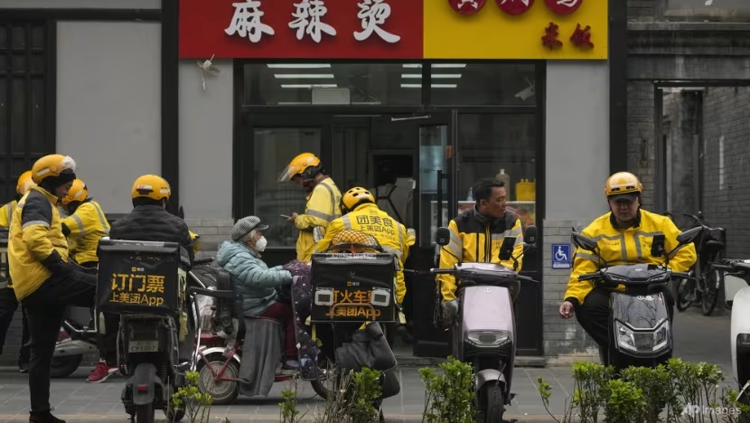 Các tài xế công nghệ chờ bên ngoài một nhà hàng tại Bắc Kinh, Trung Quốc. Ảnh: AP