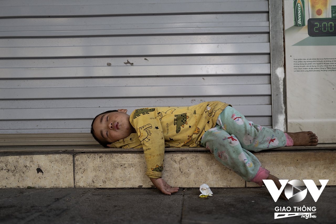 Em bé ngủ trên vỉa hè phố Quán Sứ trong lúc chờ bố mẹ giải quyết công việc
