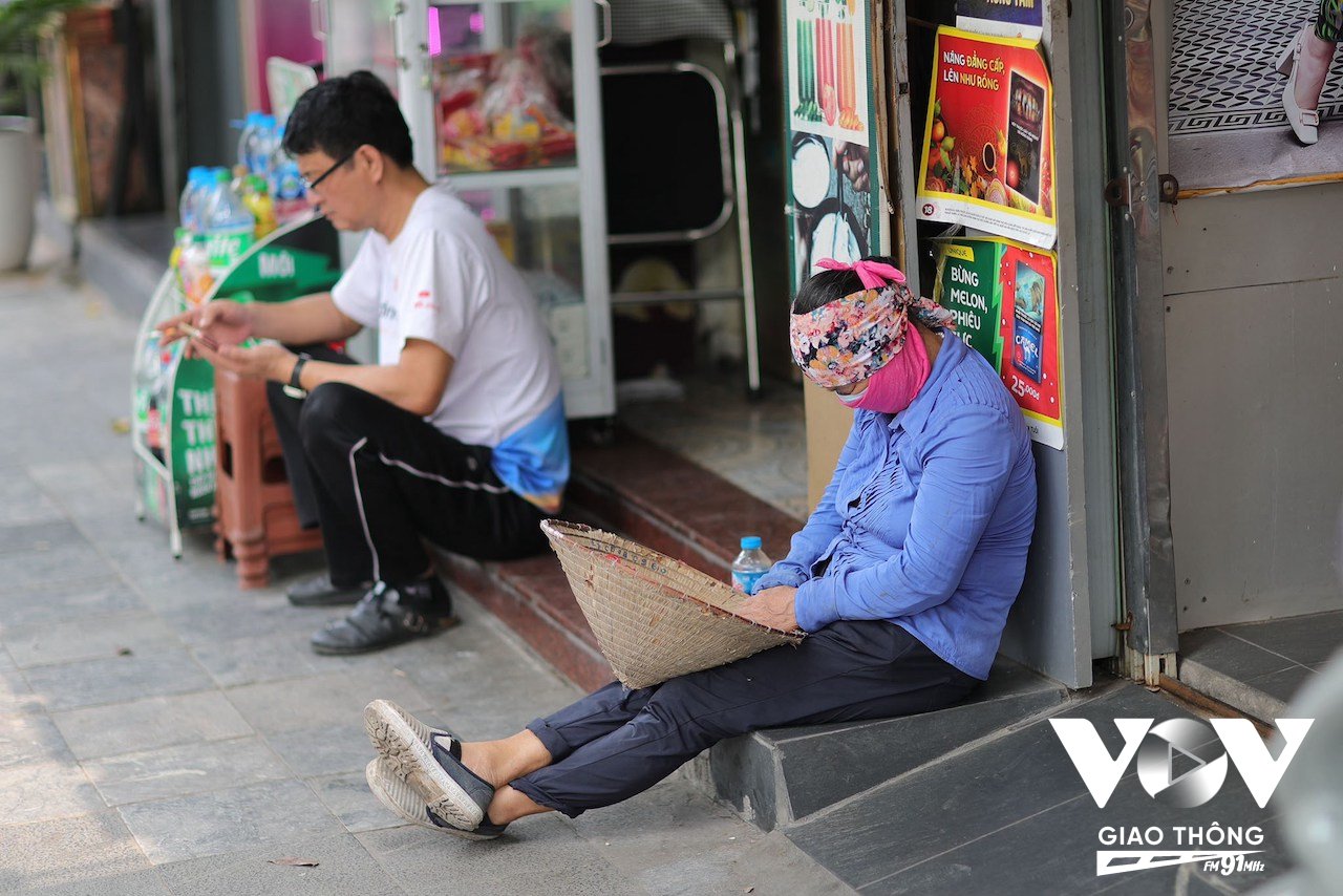 Người phụ nữ ngủ ngồi trên vỉa hè phố Hàng Bông mặc cái nóng như thiêu đốt giữa trưa hè