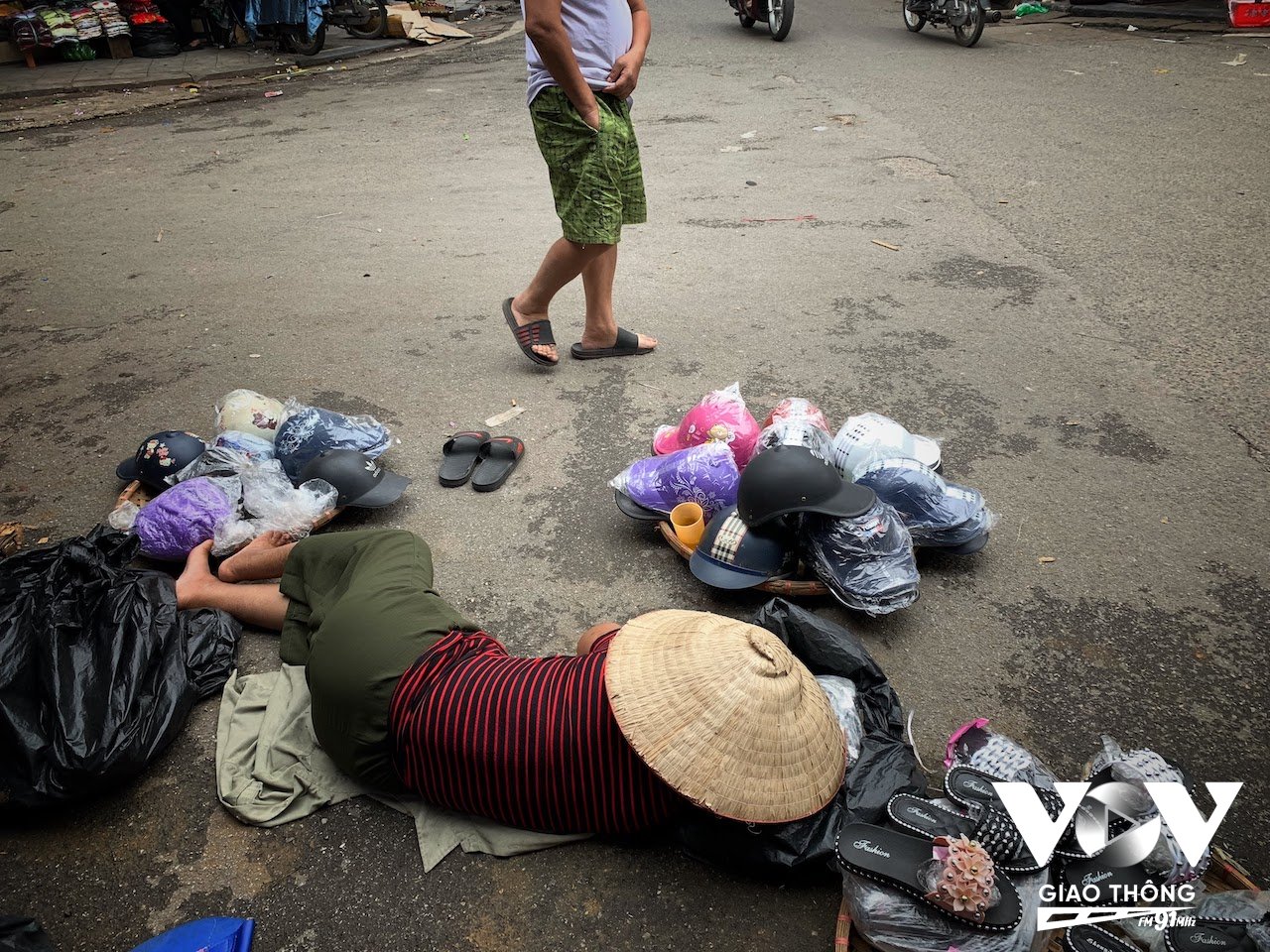 Giờ nghỉ trưa của một người phụ nữ bán hàng rong trên phố Nguyễn Thiếp, Hà Nội