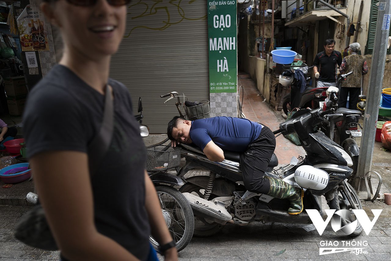 Tư thế nào cũng 'đưa anh vào giấc ngủ' được. Một người chở hàng thuê ngủ vùi trên yên xe máy giữa trưa hè trong ngõ chợ Yên Thái