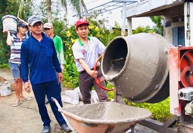 Anh Nguyễn Văn Tiến (bìa phải) trộn hồ làm đường nông thôn tại xã Tân Thành, TP.Ngã Bảy, Hậu Giang. Ảnh: Thanh niên