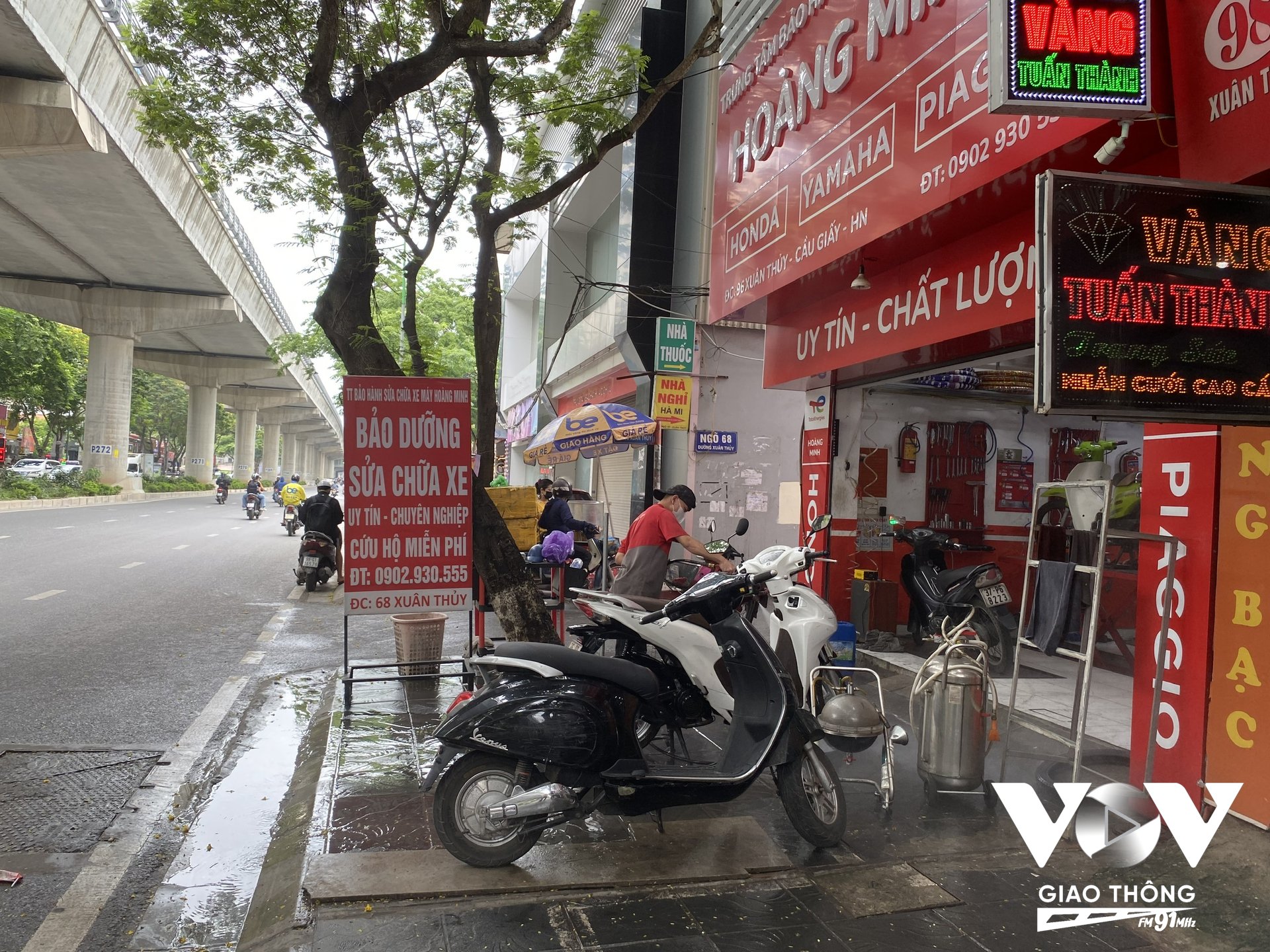 Một cửa hàng rửa xe máy tại đường Xuân Thủy (Cầu Giấy, Hà Nội) chiếm dụng hết phần vỉa hè để rửa xe cho khách