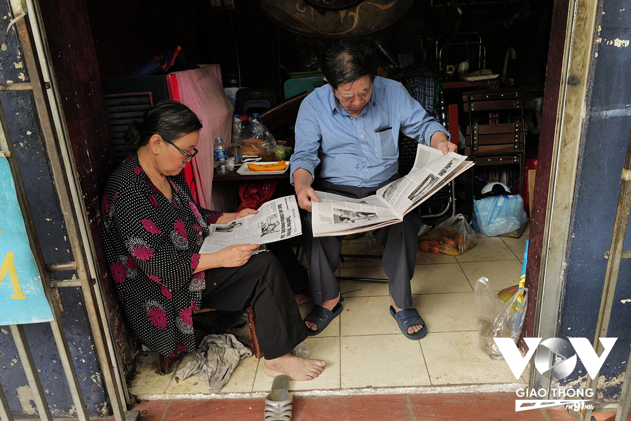 Đôi vợ chồng già cùng nhau đọc báo sớm trên phố Đường Thành...