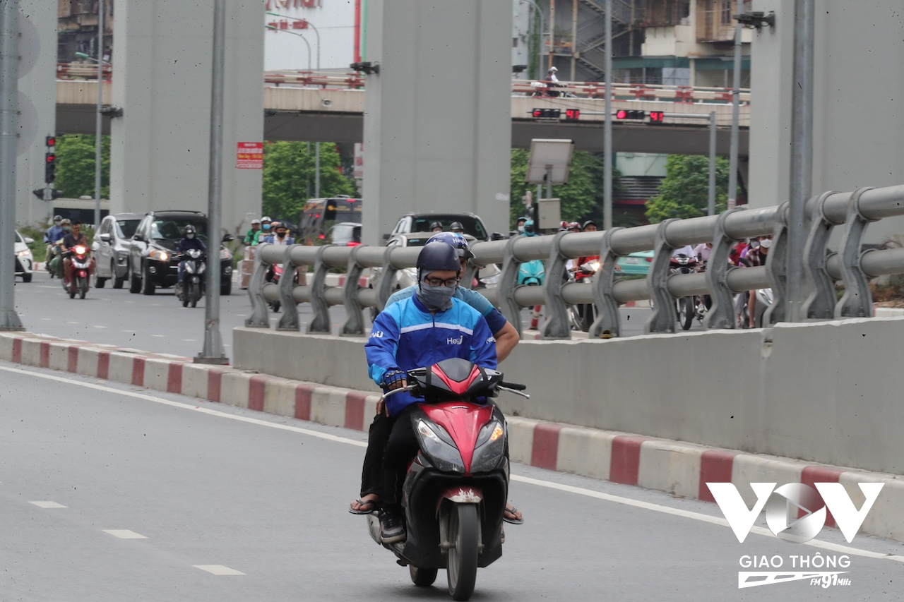 Một người lái xe công nghệ vừa chở khách, vừa xem điện thoại khi tham gia giao thông trên đường Minh Khai