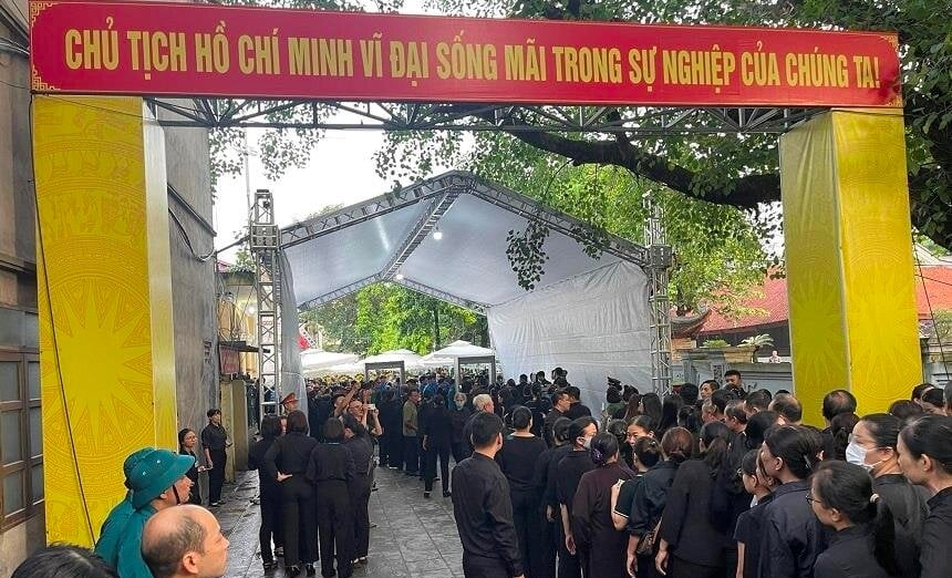 Hàng trăm người dân làng Lại Đà (Đông Anh, Hà Nội) trong trang phục quần đen áo đen xếp hàng kiểm tra an ninh vào chờ viếng Tổng Bí thư.