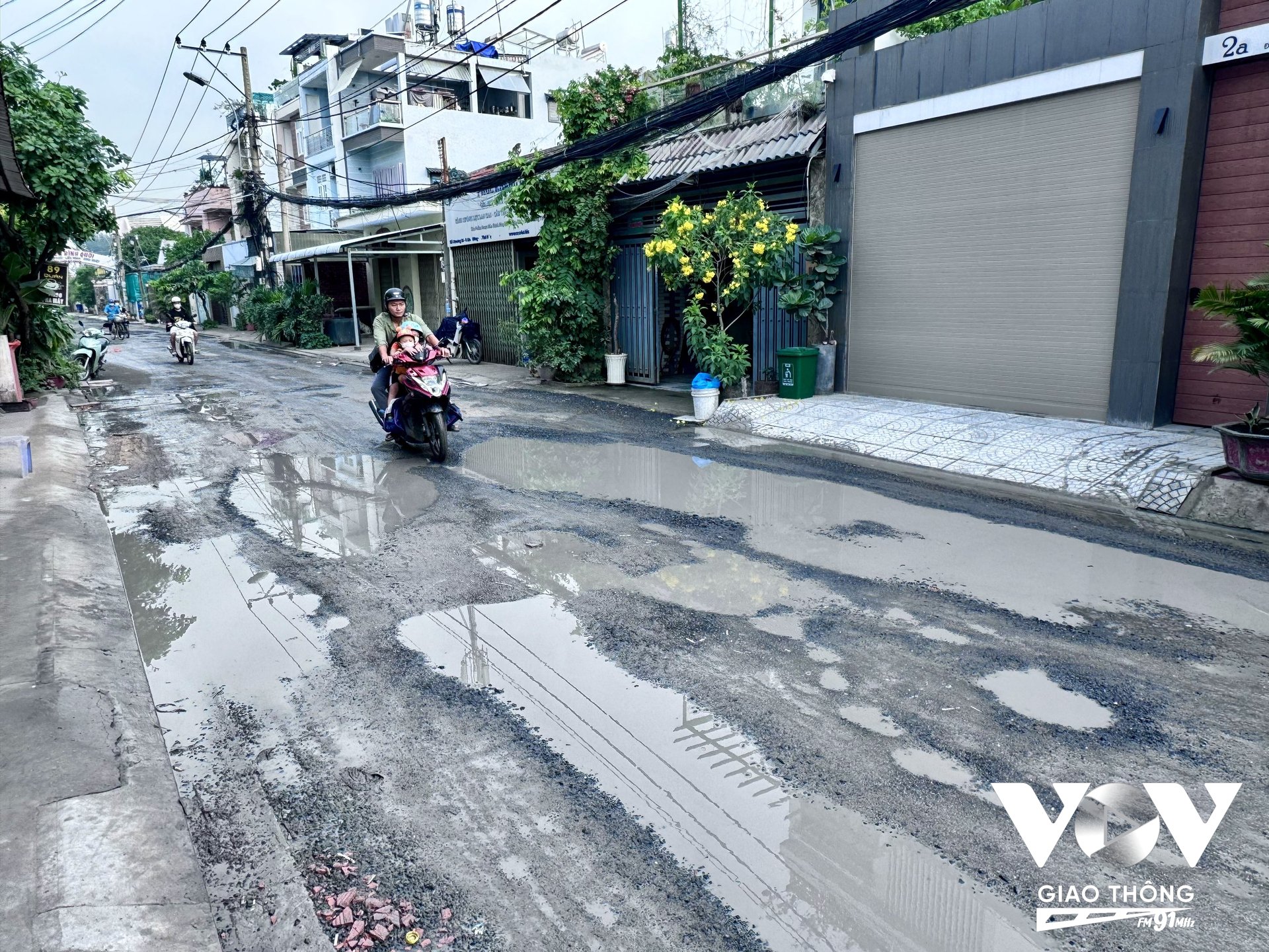 Trời mưa, nước tù đọng trong những ổ gà ổ voi giăng bẫy người đi đường