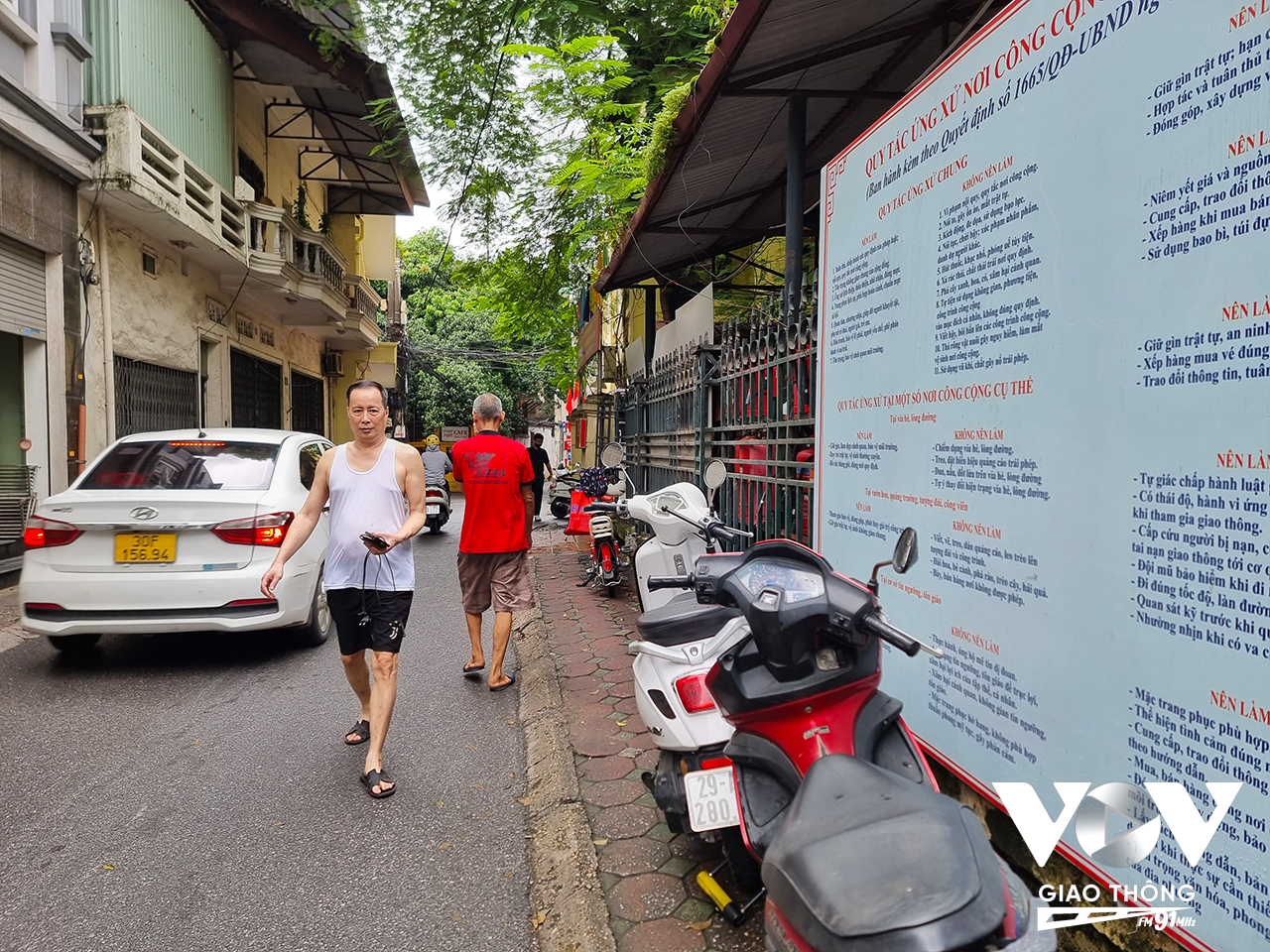 Khu vực vỉa hè quanh UBND phố Yên Hòa, xe đỗ la liệt khiến người dân phải đi bộ dưới lòng đường.