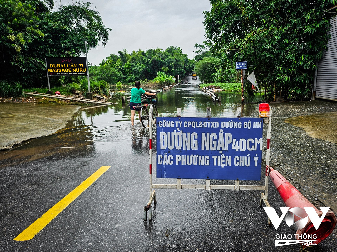 Lực lượng chức năng đặt biển cảnh báo lượng nước vẫn còn ngập trên cầu