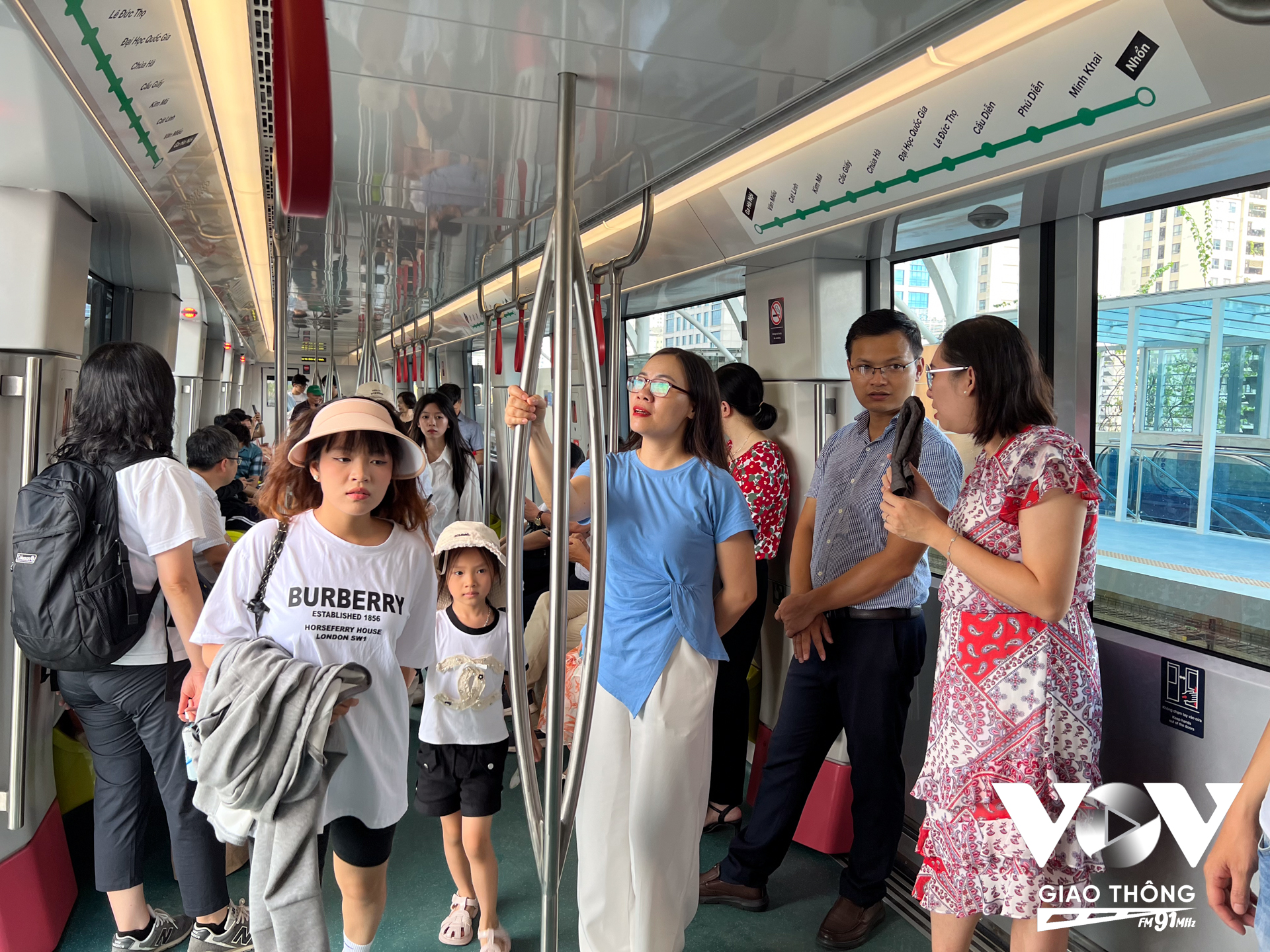 Phía bên trong tàu điện chật kín người. Nhiều hành khách phải đứng. Tuy vậy, tất cả đều tỏ ra vô cùng hào hứng