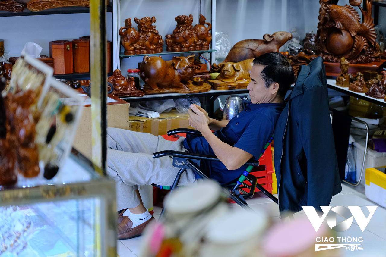 Nhiều tiểu thương chỉ còn biết lướt điện thoại để ‘giết’ thời gian.