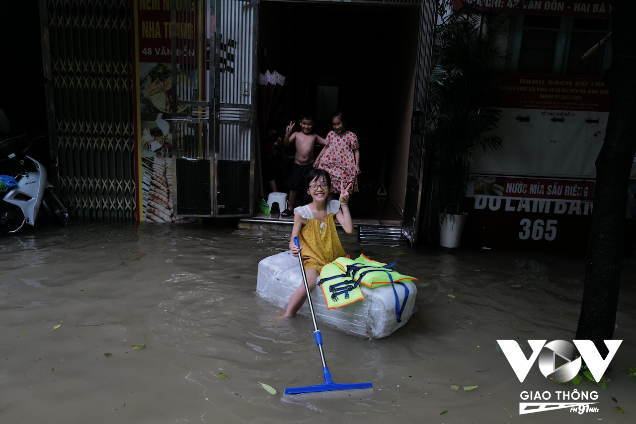 Những đứa trẻ thì hồn nhiên chơi đùa với nước lụt