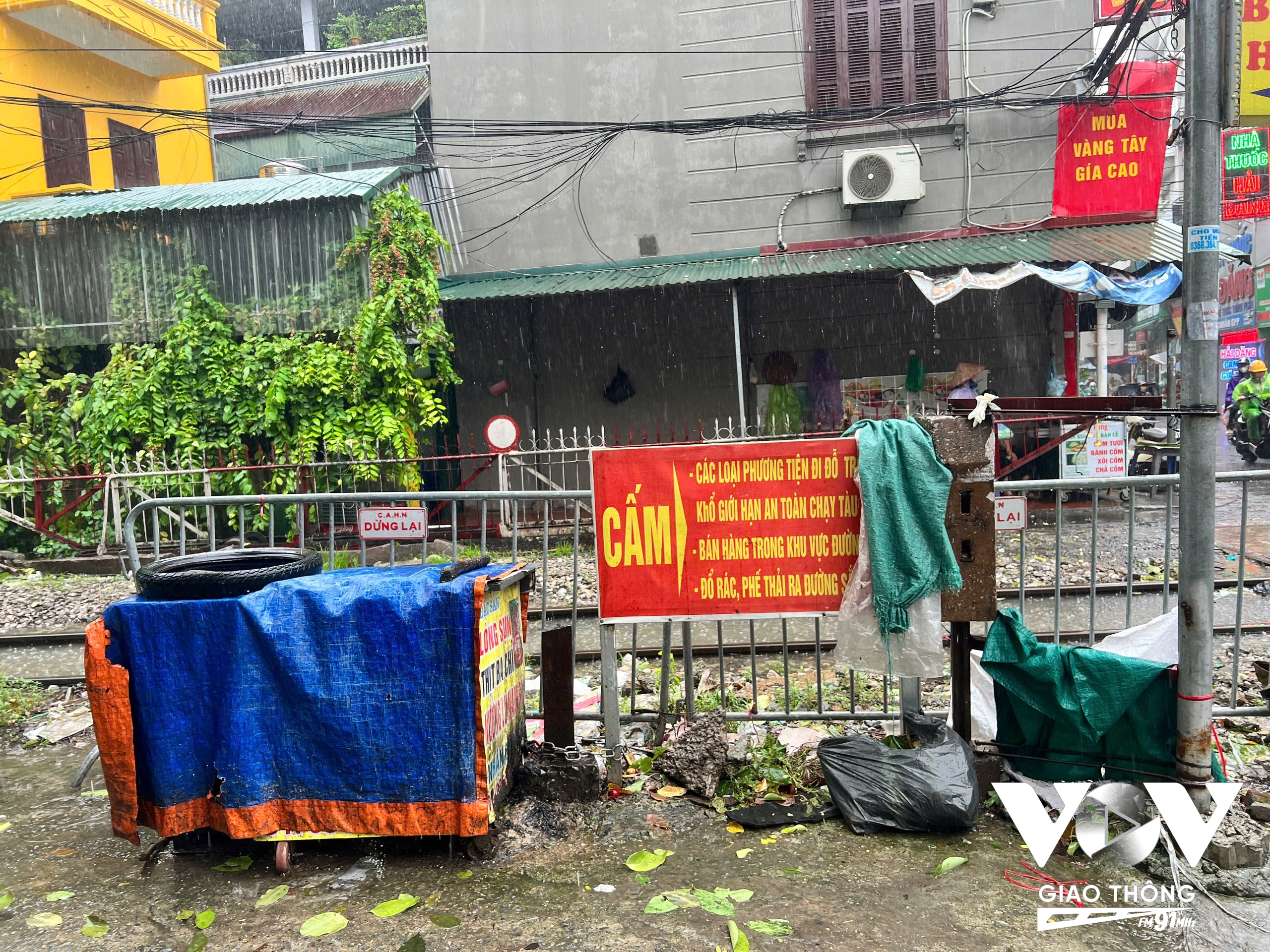 Các tiểu thương phớt lờ biển cấm bán hàng trên khu vực đường ngang, thậm chí biển cấm còn là nơi vắt áo mưa.