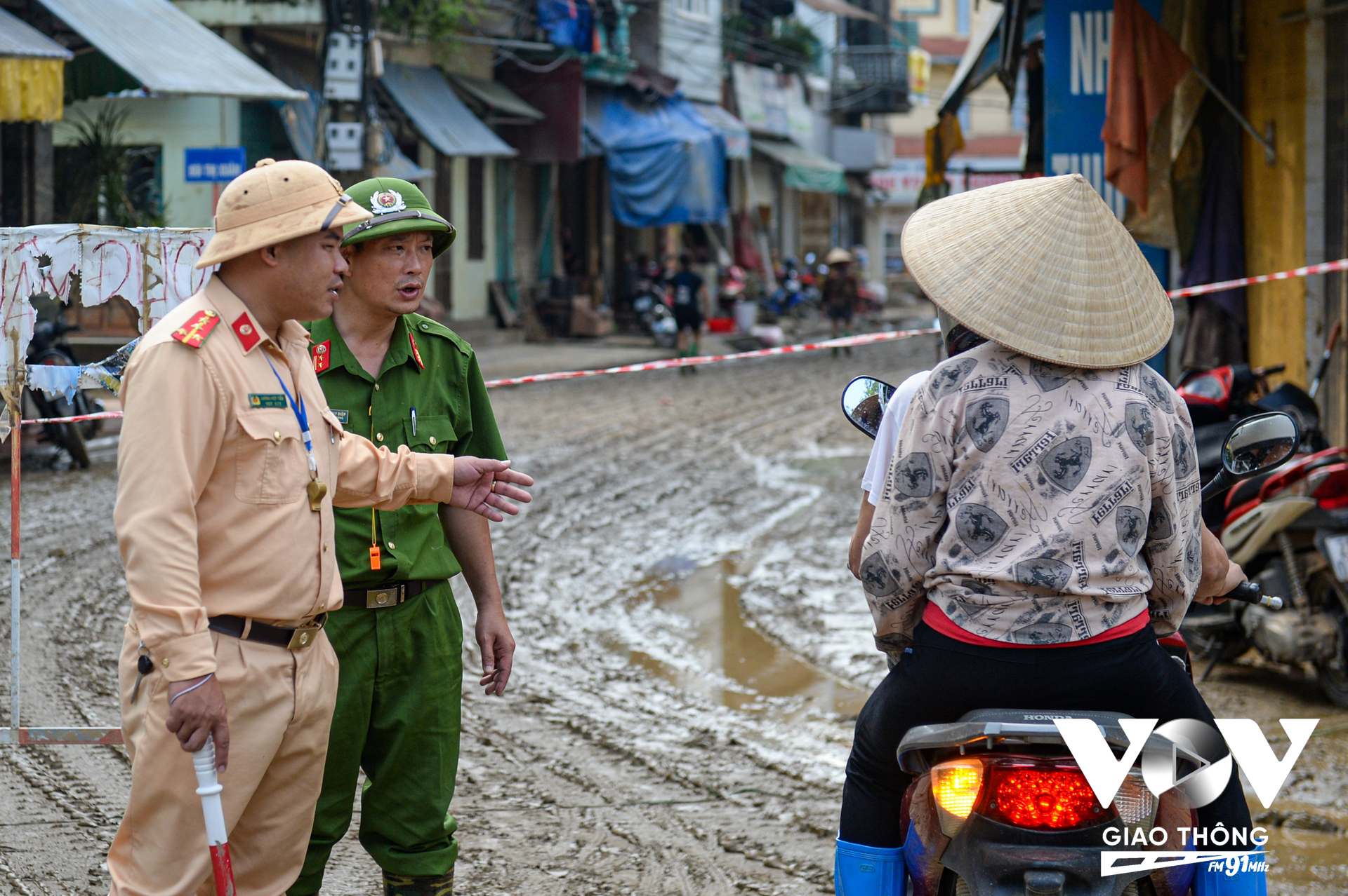 Ở đầu phố Trần Quang Khải, nơi dẫn vào đường Thanh Niên (tuyến đường còn nhiều bùn đất) có lực lượng CSGT và Công phường sở tại trực chốt, để phân luồng, hướng dẫn người dân đi lại, cùng với đó đảm bảo giao thông thông suốt cho những chuyến xe chở bùn đến nơi tập kết.