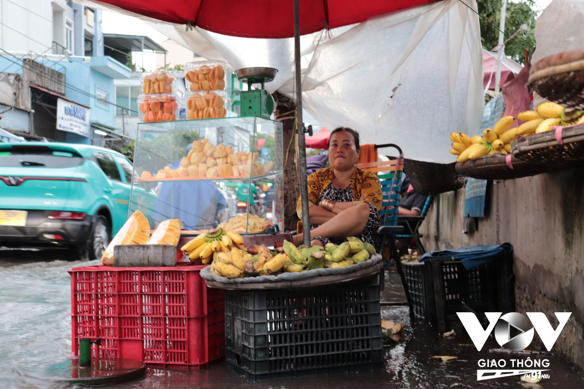 Một hộ kinh doanh trái cây đường Trân Xuân Soạn (quận 7, TP.HCM) ủ rũ vì nước dân khiến việc buôn bán khó khăn.