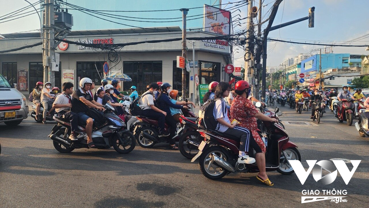 Nhiều phụ huynh học sinh đưa đón con em đi học nhưng khộng đội mũ bảo hiểm cho các em