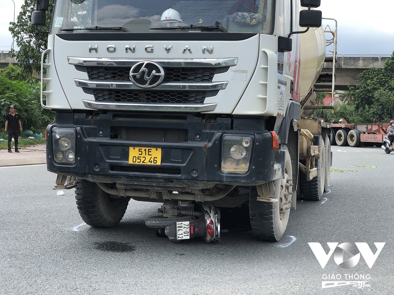 Xe máy bị cuốn vào gầm xe tải