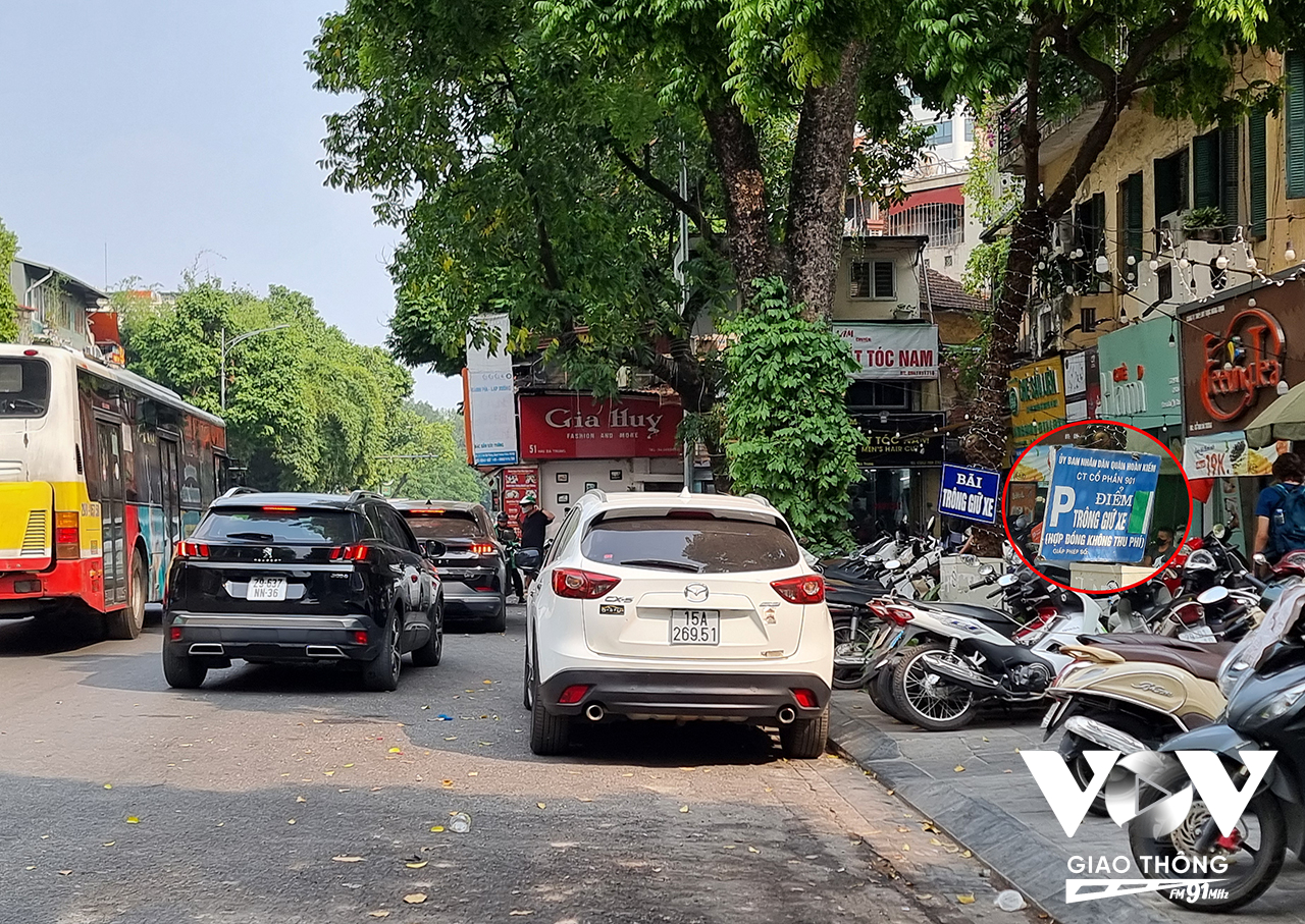 Tuy nhiên, vẫn còn tình trạng trông giữ xe ô tô dưới lòng đường tại trước của nhà số 53 – 55 phố Hai Bà Trưng. Trong ảnh, các xe dừng đỗ thành 2 hàng dưới lòng đường. Điều đáng nói, sau phản ánh của Kênh VOV Giao thông, điểm trông giữ xe này vốn được treo tấm biển trông giữ xe của công ty cổ phần 901. Thế nhưng nay đã bị gỡ xuống và chỉ để tấm biển tự ghi như thế này? Liệu tấm biển trông giữ xe này có đúng với quy định? Hàng ngày sẽ có bao nhiêu ô tô phải bị “mất tiền oan” tại đây?