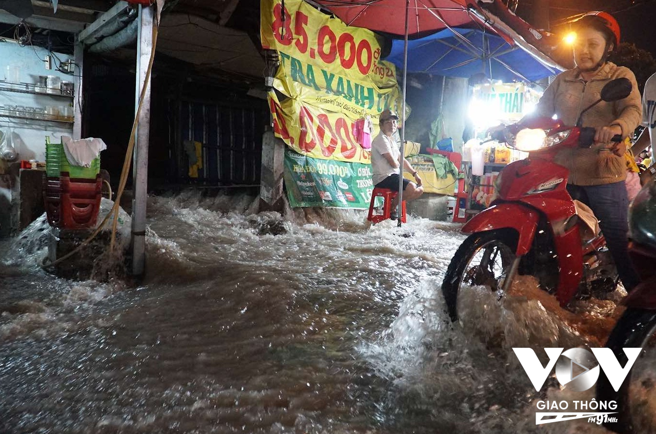 Nước chảy ngược từ cống lên đường trở lại cuốn xiết khiến các phương tiện di chuyển hết sức khó khăn