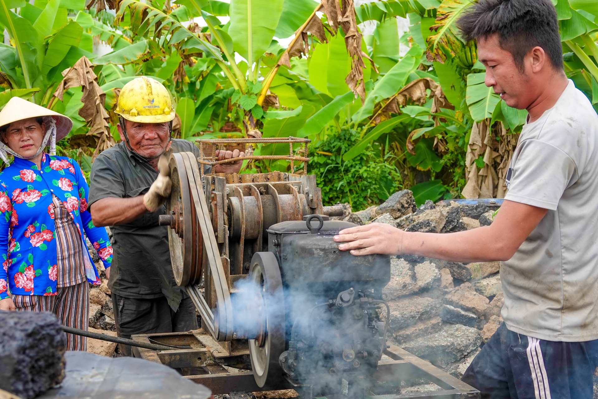 Công việc của ông Ba Dân bớt vất vả hơn nhờ chiếc máy nghiền nhựa phế thải tự chế. Ảnh: Thanh niên