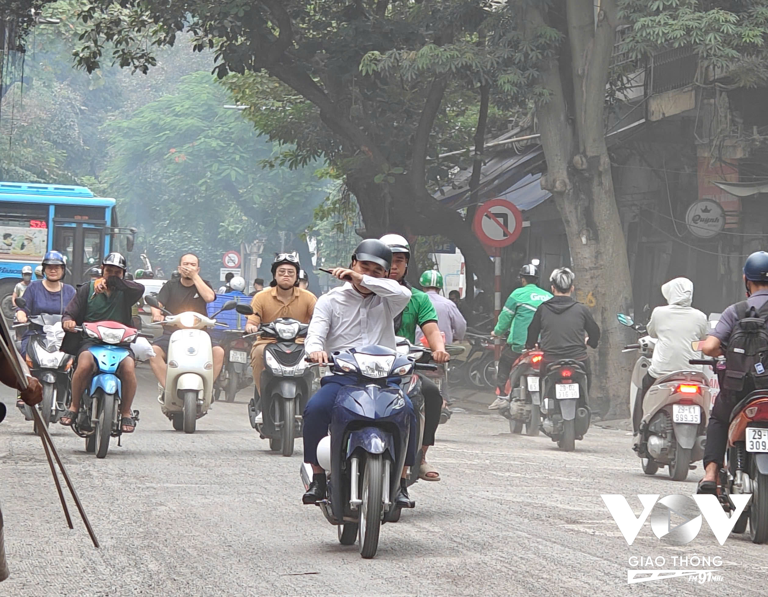 Bụi mù mịt trên tuyến đường có nhiều xe cộ qua lại và thi công cào sửa mặt đường.