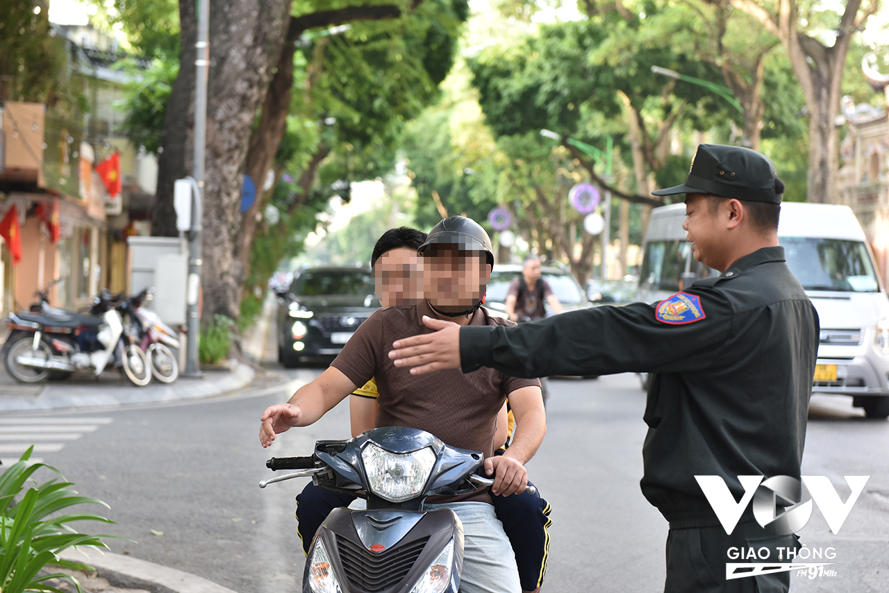 Người đàn ông trong ảnh được lực lượng chức năng yêu cầu dừng xe để kiểm tra vì điều khiển phương tiện, chở theo người ngồi sau không đội mũ bảo hiểm.