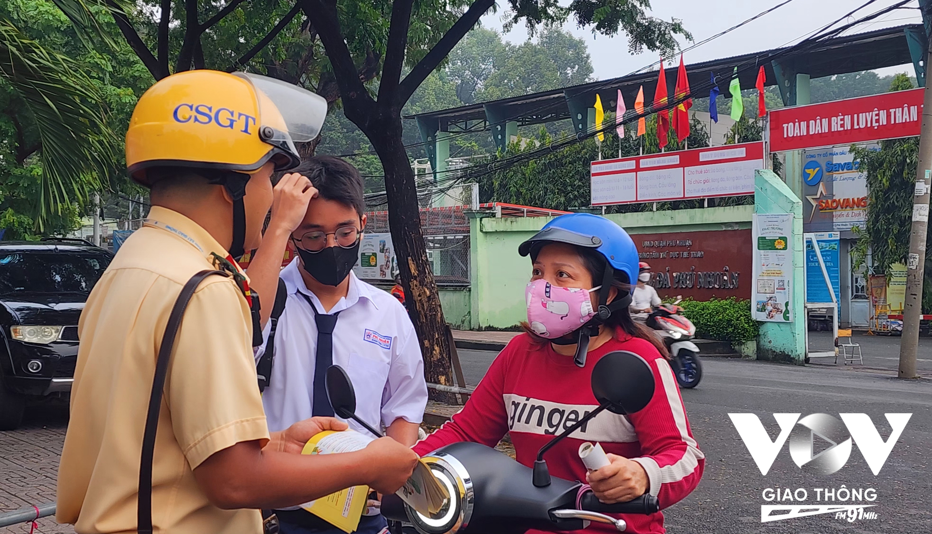 Lực lượng CSGT Công an quận Phú Nhuận phát tờ rơi tuyên truyền luật giao thông đường bộ cho phụ huynh học sinh trước cổng trường