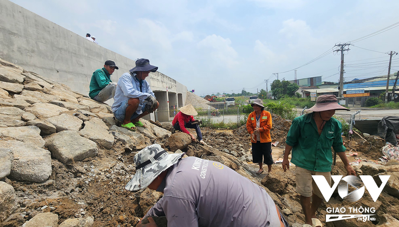 Công nhân đang khẩn trương thi công ốp đá hai bên mặt cầu để bảo vệ mố cầu thuộc dự án cao tốc Bến Lức - Long Thành.