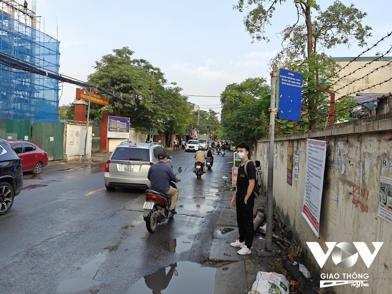 Một sinh viên Đại học Kinh tế Kỹ thuật Công nghiệp trên đường Lĩnh Nam đứng chơ vơ ở điểm chờ xe buýt.